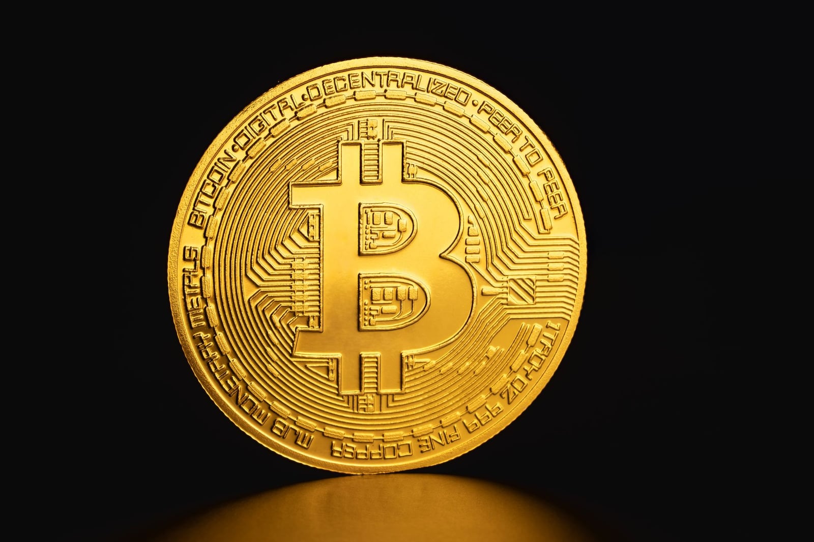 Primer plano de una moneda Bitcoin dorada sobre un fondo oscuro que simboliza criptomonedas y finanzas digitales.