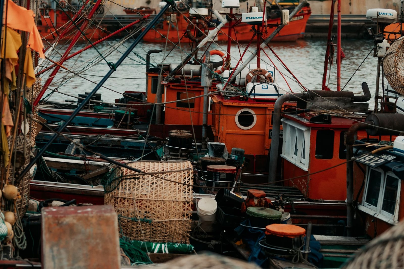 Vista de cerca de coloridos barcos de pesca atracados de forma segura en un puerto bullicioso.