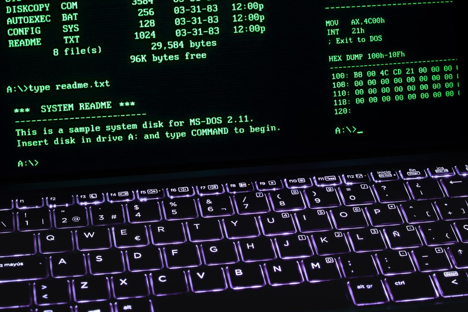 Una pantalla de terminal MS-DOS clásica mostrada en el teclado de una computadora portátil con iluminación brillante.