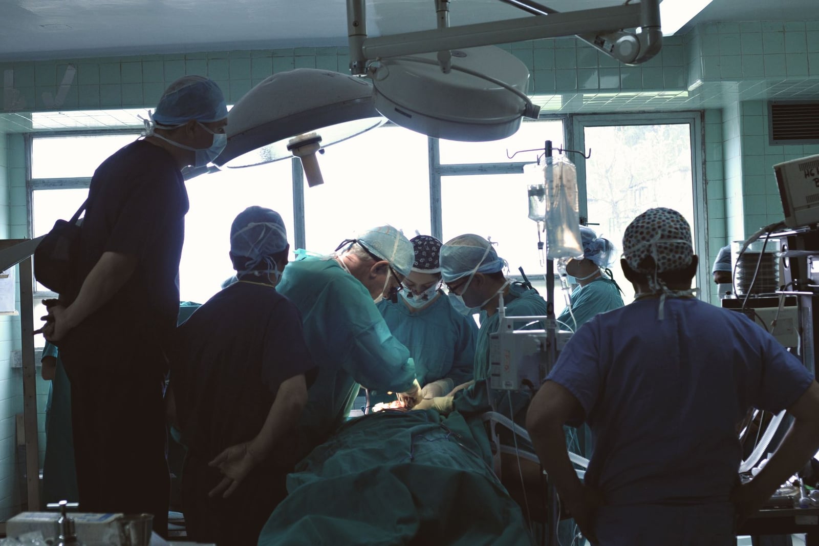 Equipo médico que realiza una cirugía en un entorno hospitalario con atención concentrada.