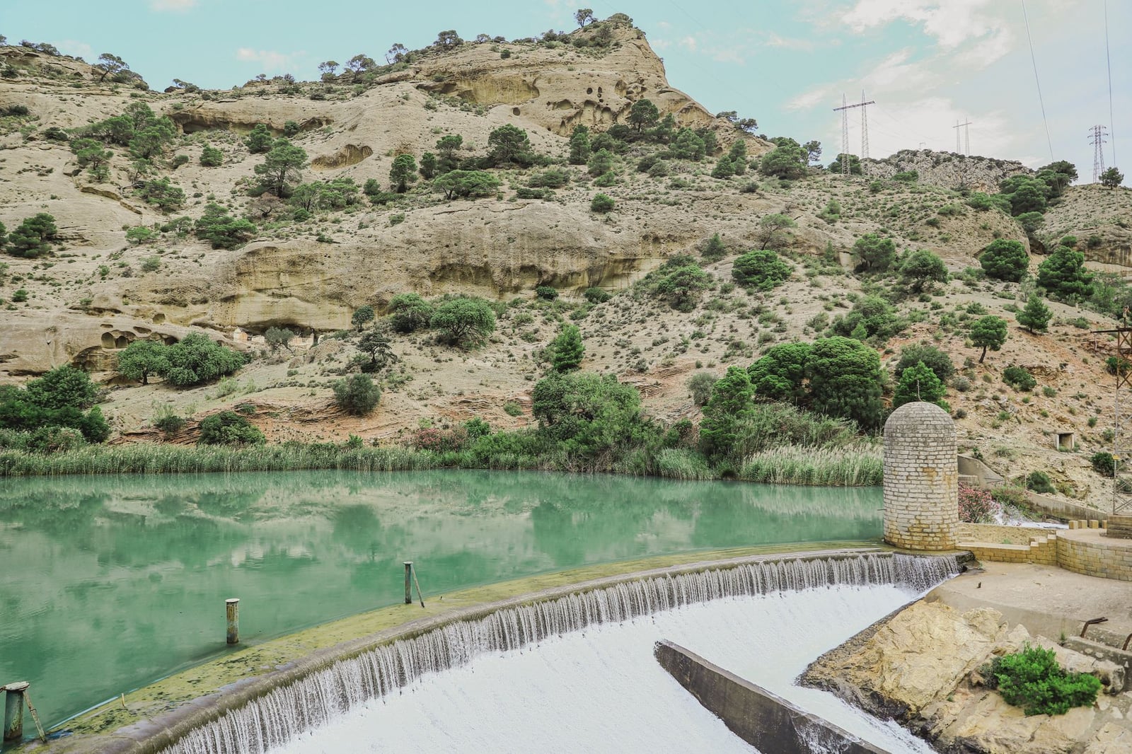 Hermosa vista de la cascada de la Presa de Ardales rodeada de montañas escarpadas en España.