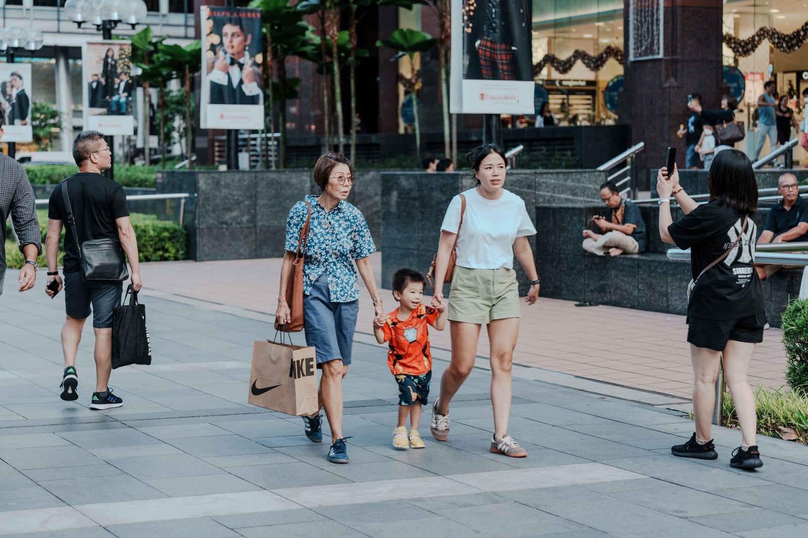 Una animada escena callejera urbana con compradores y familias, que captura la vibrante vida de la ciudad.